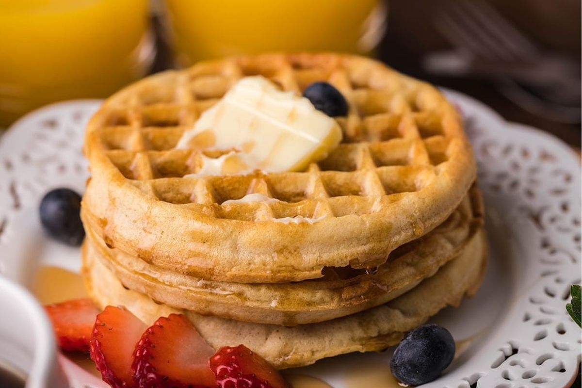 Air Fryer Frozen Waffles on plate with butter and fresh fruit..