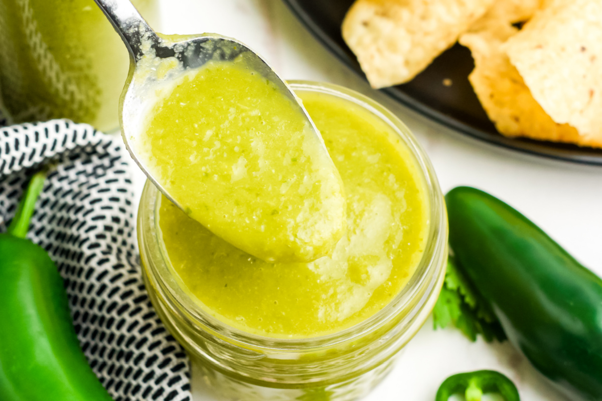 A spoonful of hot sauce above a jar full.